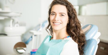 smiling young woman sitting chair dental clinic