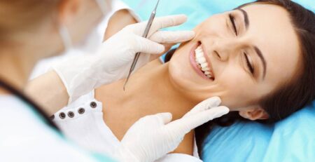 young female patient visiting dentist office beautiful woman with healthy straight white teeth sitting dental chair with open mouth during oral checkup while doctor working teeth dental clinic